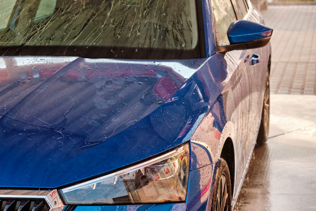 close up hood and headlight of a blue car in a dro 2026 03 19 09 23 49 utc