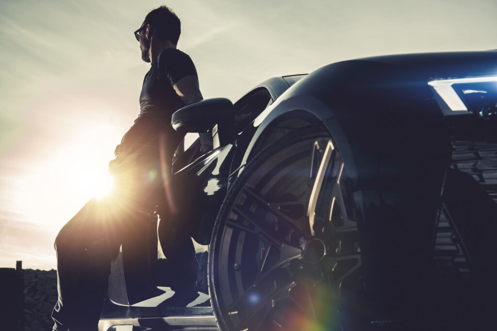 man leaning on black car in sunlight 2026 03 24 09 07 12 utc